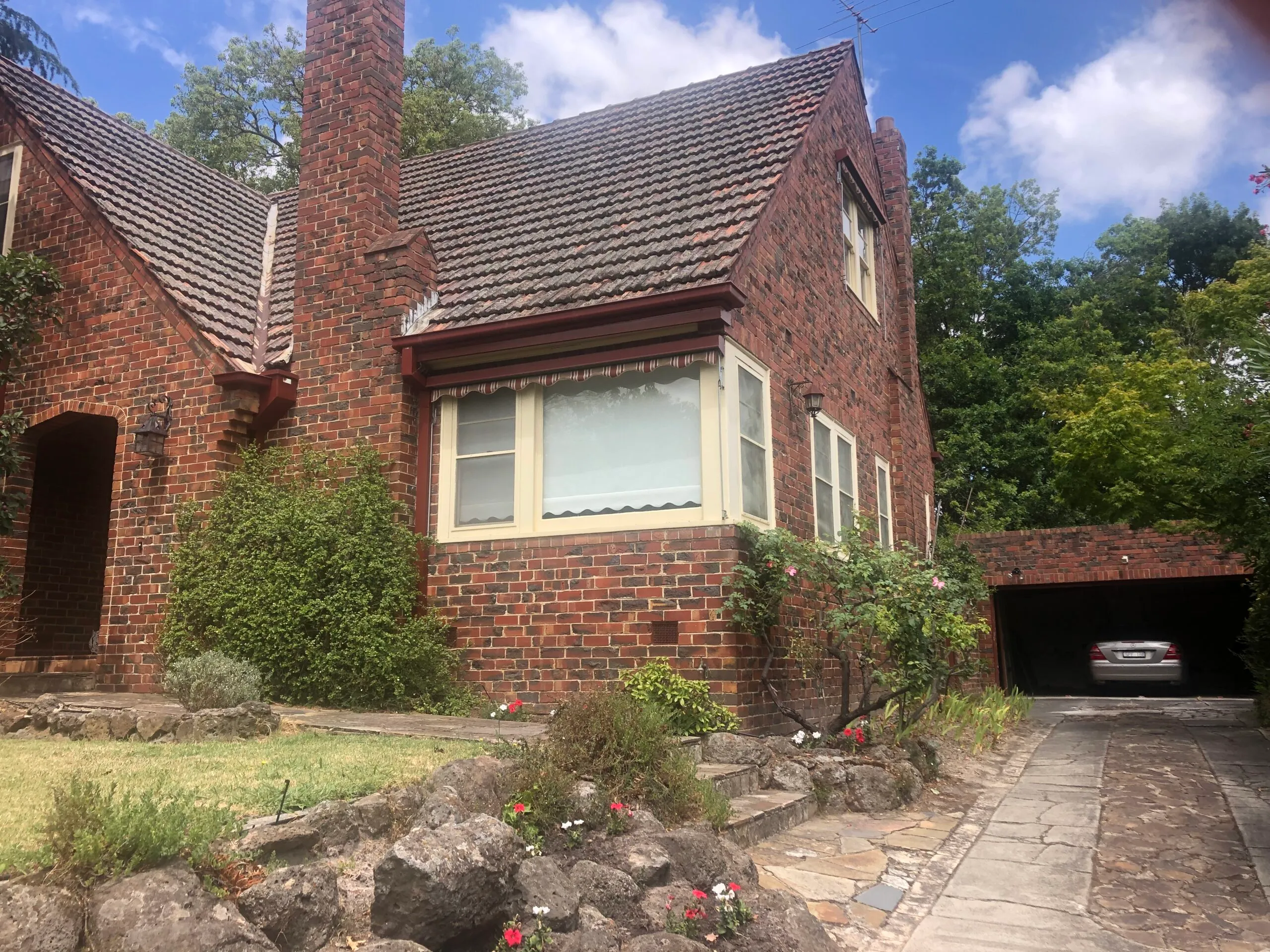 Heritage red-brick Melbourne home with freshly painted cream window frames and timber trim